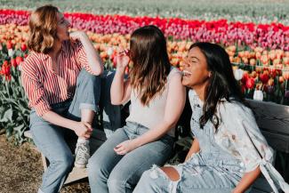 Three women laughing in a park